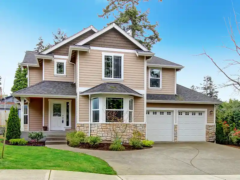 Mid-class tan home with a gray shingle roof